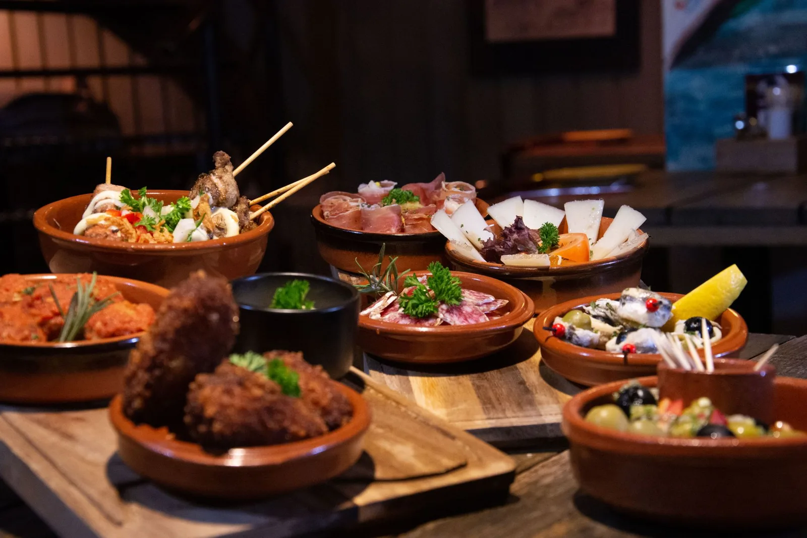 A spread of Spanish tapas dishes on a wooden table