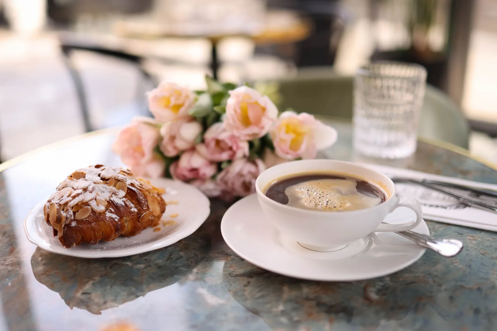 A fresh croissant and a cup of coffee at a Paris cafe table